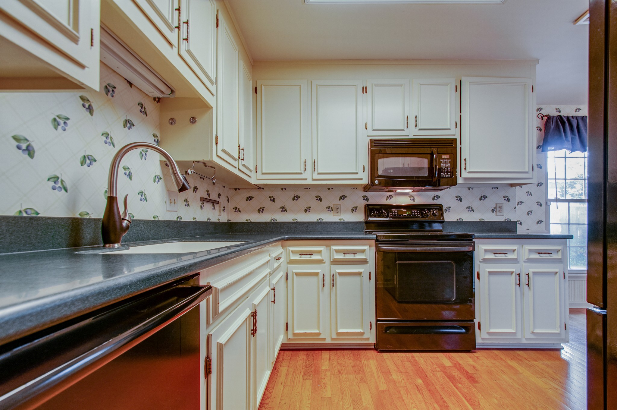 1127 General George Patton Road Nashville, TN 37221 - Photo 10 of 30 a kitchen with granite countertop a stove and a sink
