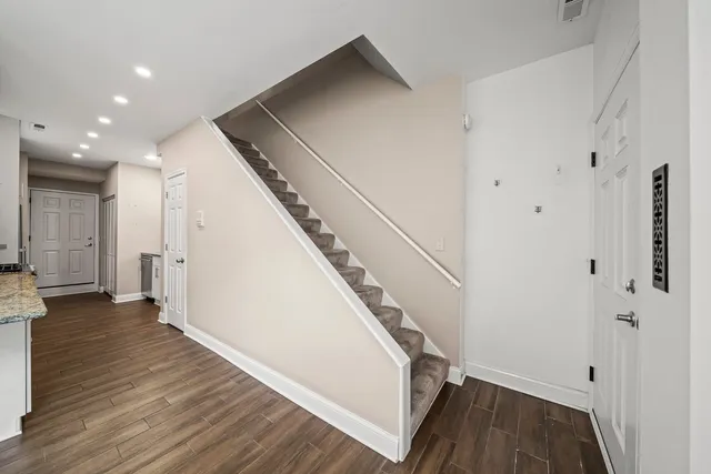 a view of a hallway with wooden floor and staircase