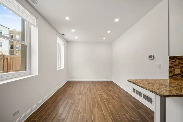 a view of a kitchen with wooden floor and window