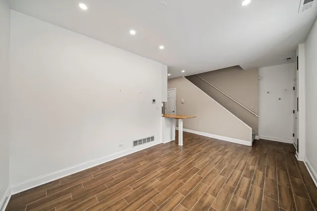 a view of empty room with wooden floor