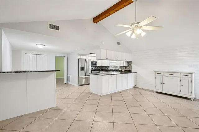 a kitchen with white cabinets and white appliances