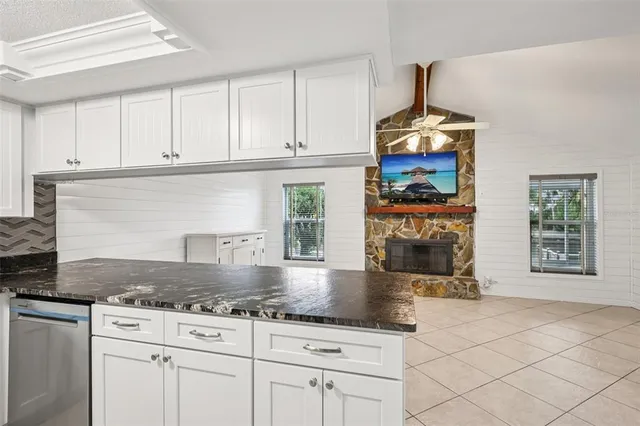 a kitchen with stainless steel appliances granite countertop a stove and a white cabinets