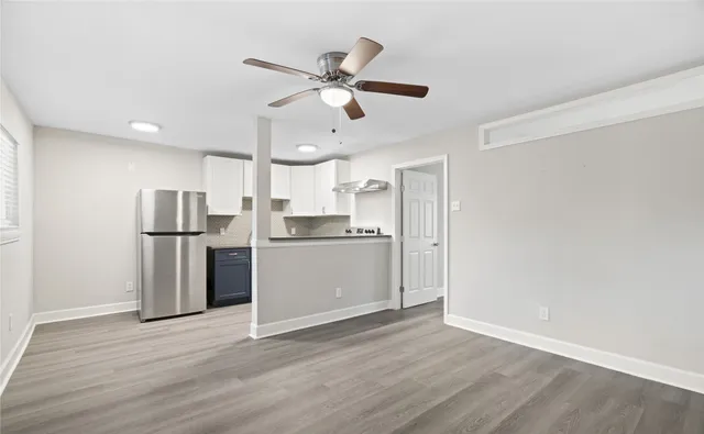 a view of kitchen with stainless steel appliances refrigerator stove and wooden floor