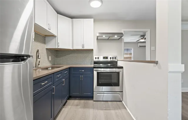 a kitchen with stainless steel appliances granite countertop a refrigerator and a stove