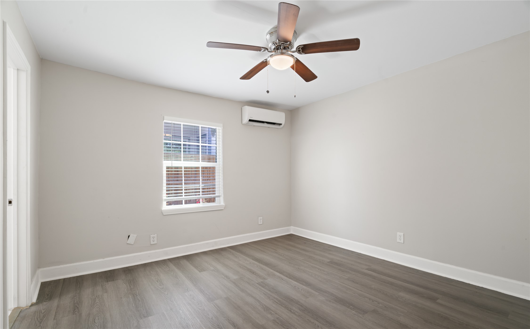 6810 Del Rio Street, Unit 4 Houston, TX 77021 - Photo 9 of 13 an empty room with wooden floor ceiling fan and windows