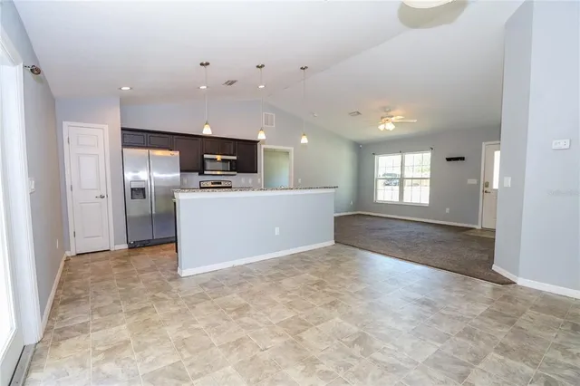 a view of a kitchen with a refrigerator a sink oven and a window