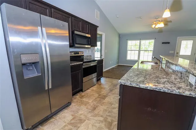 a kitchen with granite countertop kitchen island granite countertop stainless steel appliances and a counter space