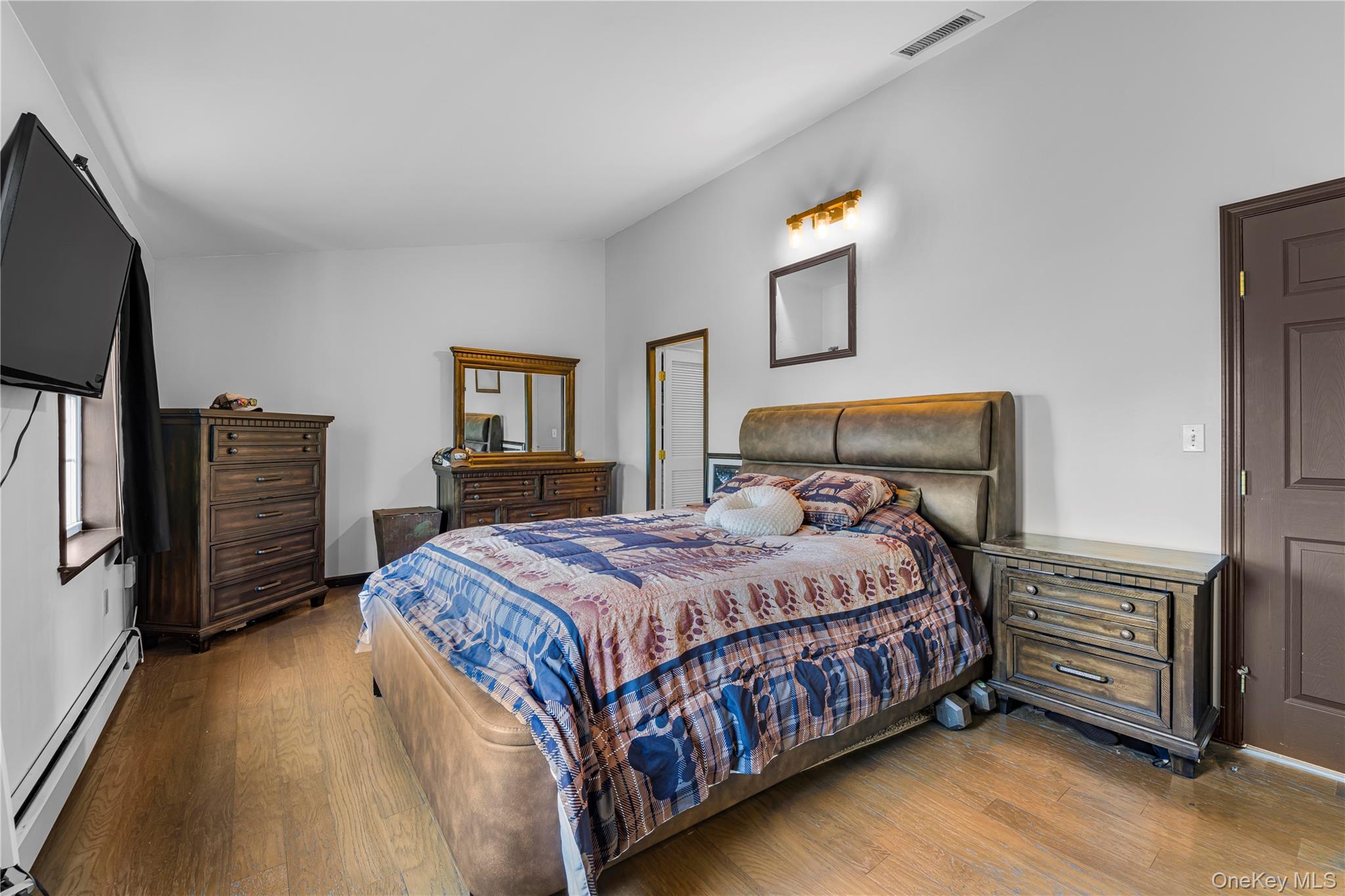 17 Brendella Court Wallkill, NY 12589 - Photo 13 of 42 Bedroom featuring baseboard heating, wood finished floors, and vaulted ceiling