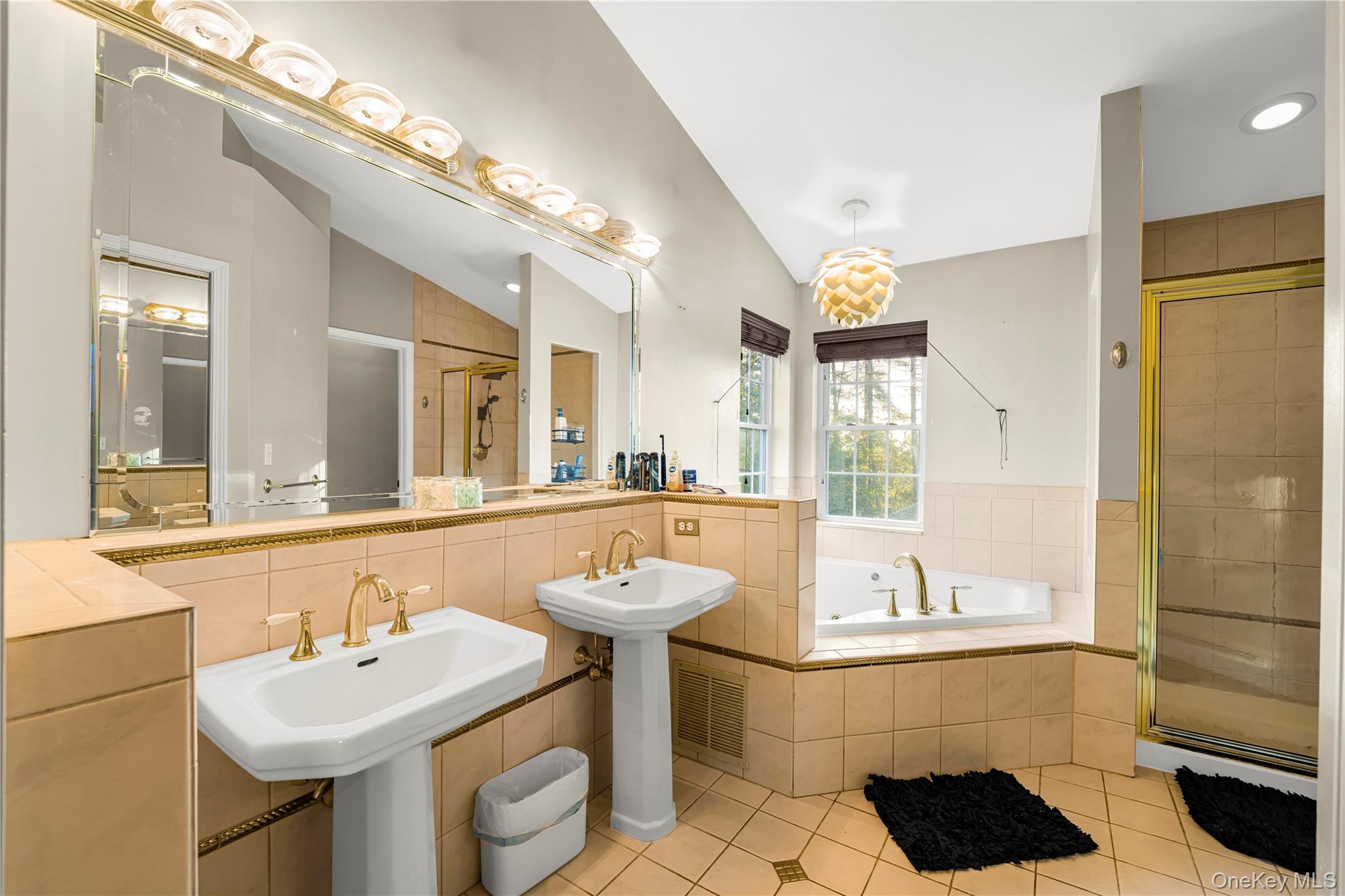 17 Brendella Court Wallkill, NY 12589 - Photo 15 of 42 Bathroom with light tile patterned floors, a stall shower, a garden tub, vaulted ceiling, and two sinks
