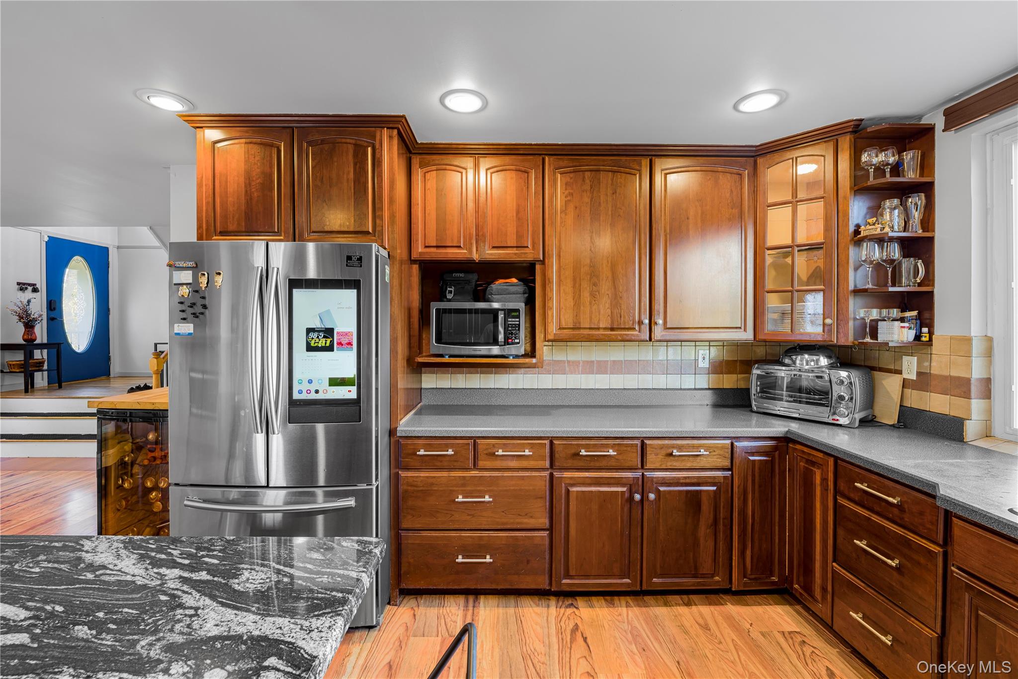 17 Brendella Court Wallkill, NY 12589 - Photo 8 of 42 Kitchen featuring open shelves, glass insert cabinets, light wood-style floors, appliances with stainless steel finishes, and tasteful backsplash
