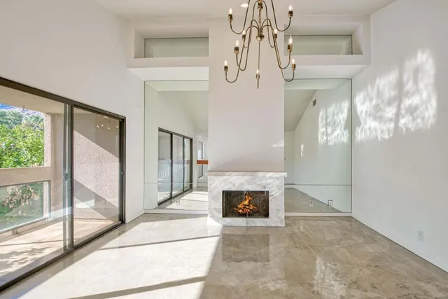 a view of a livingroom with a fireplace and chandelier