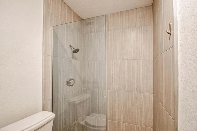 a bathroom with a shower a toilet and a sink