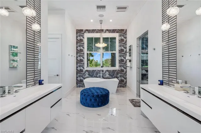 a spacious bathroom with a double vanity sink a mirror and a bathtub