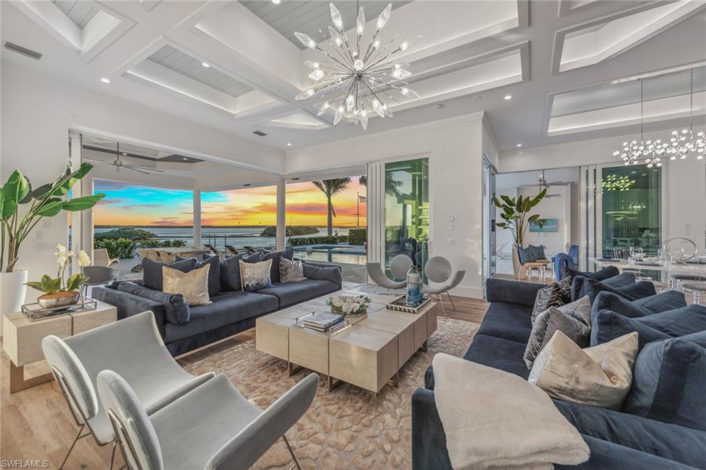 1829 South Inlet Drive Marco Island, FL 34145 - Photo 10 of 46 a living room with furniture large windows and a chandelier