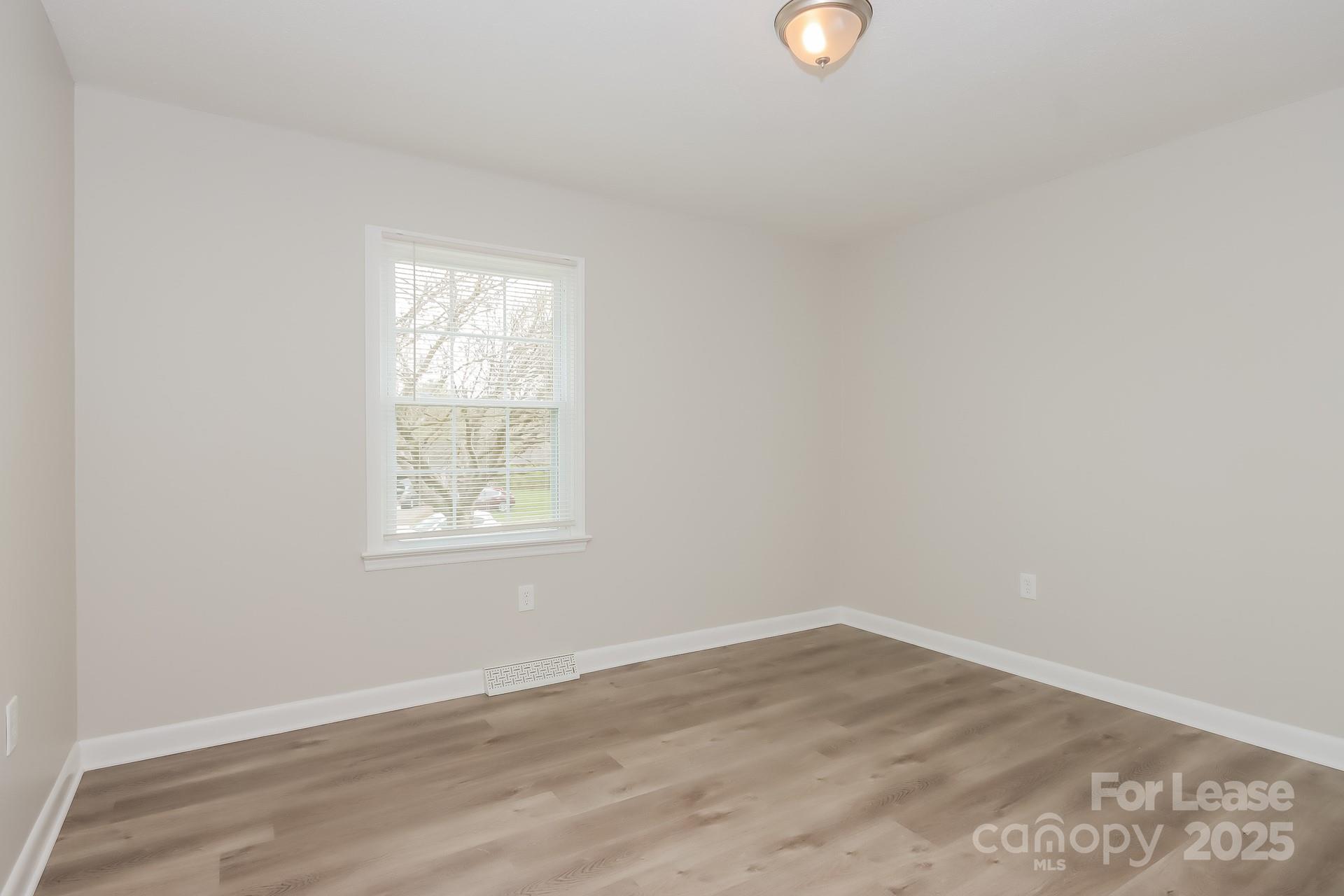 1135 Carolina Circle Statesville, NC 28677 - Photo 11 of 16 an empty room with wooden floor and windows