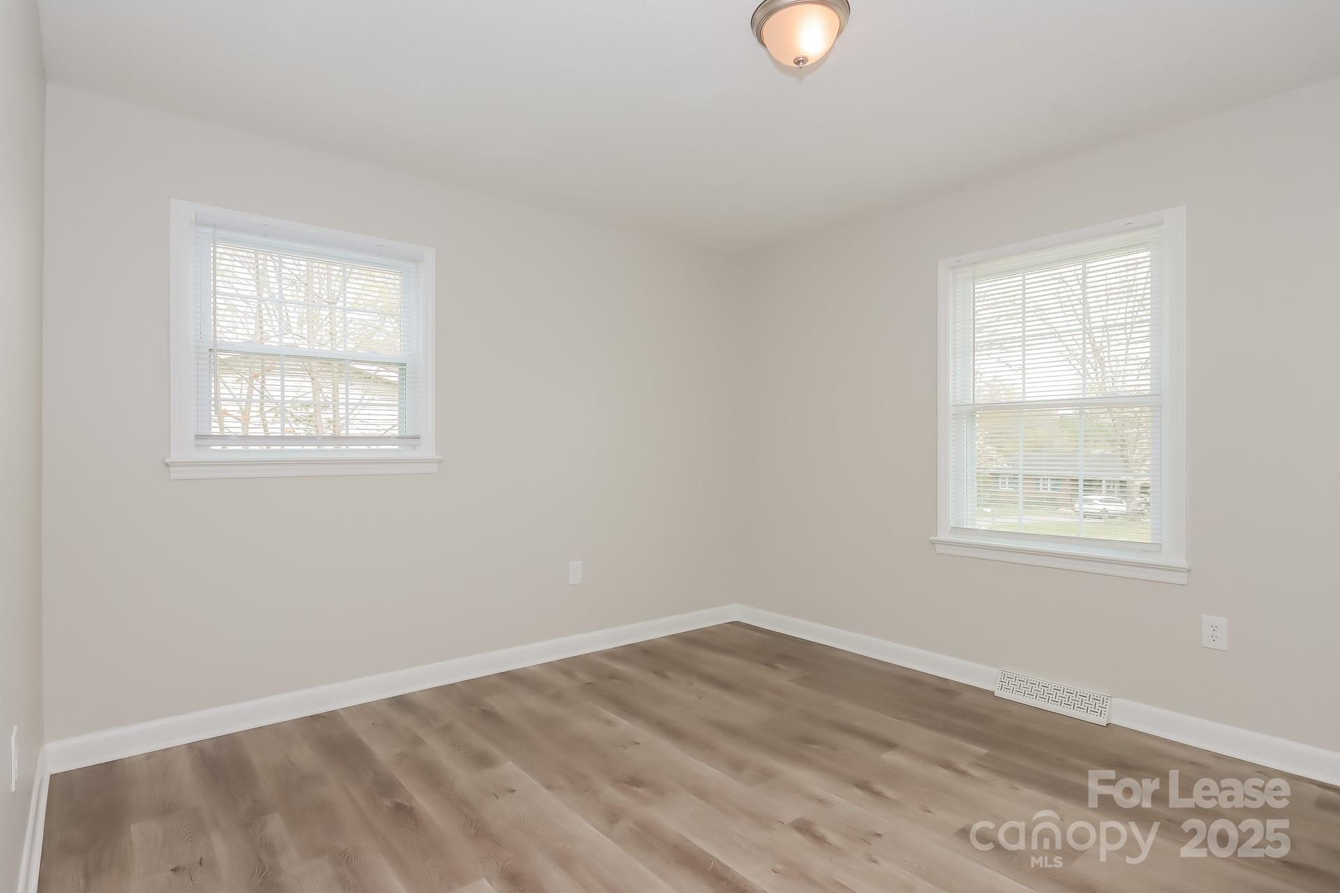 1135 Carolina Circle Statesville, NC 28677 - Photo 12 of 16 an empty room with wooden floor and windows