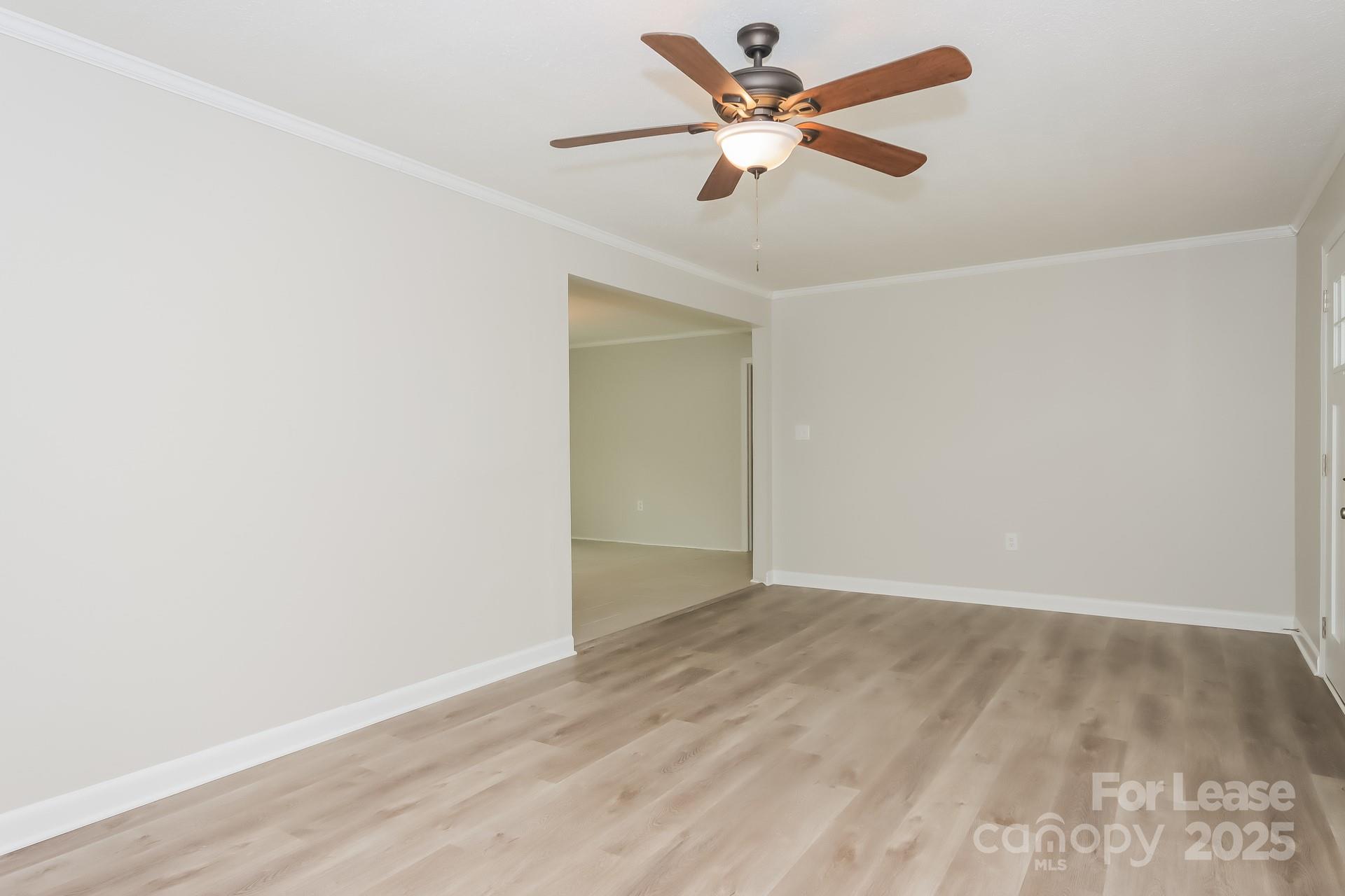 1135 Carolina Circle Statesville, NC 28677 - Photo 4 of 16 an empty room with wooden floor and a ceiling fan