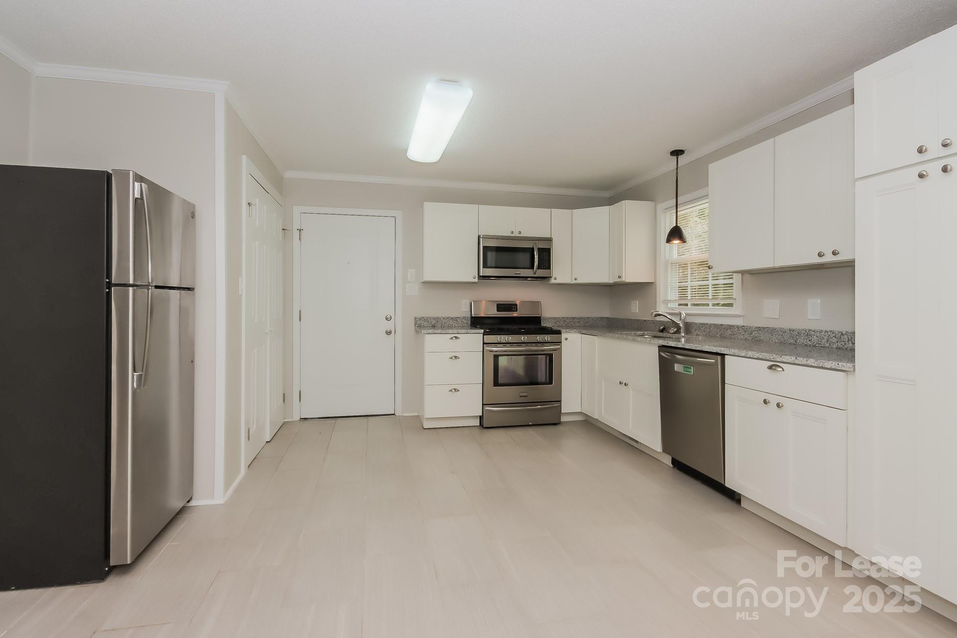 1135 Carolina Circle Statesville, NC 28677 - Photo 6 of 16 a kitchen with white cabinets and stainless steel appliances
