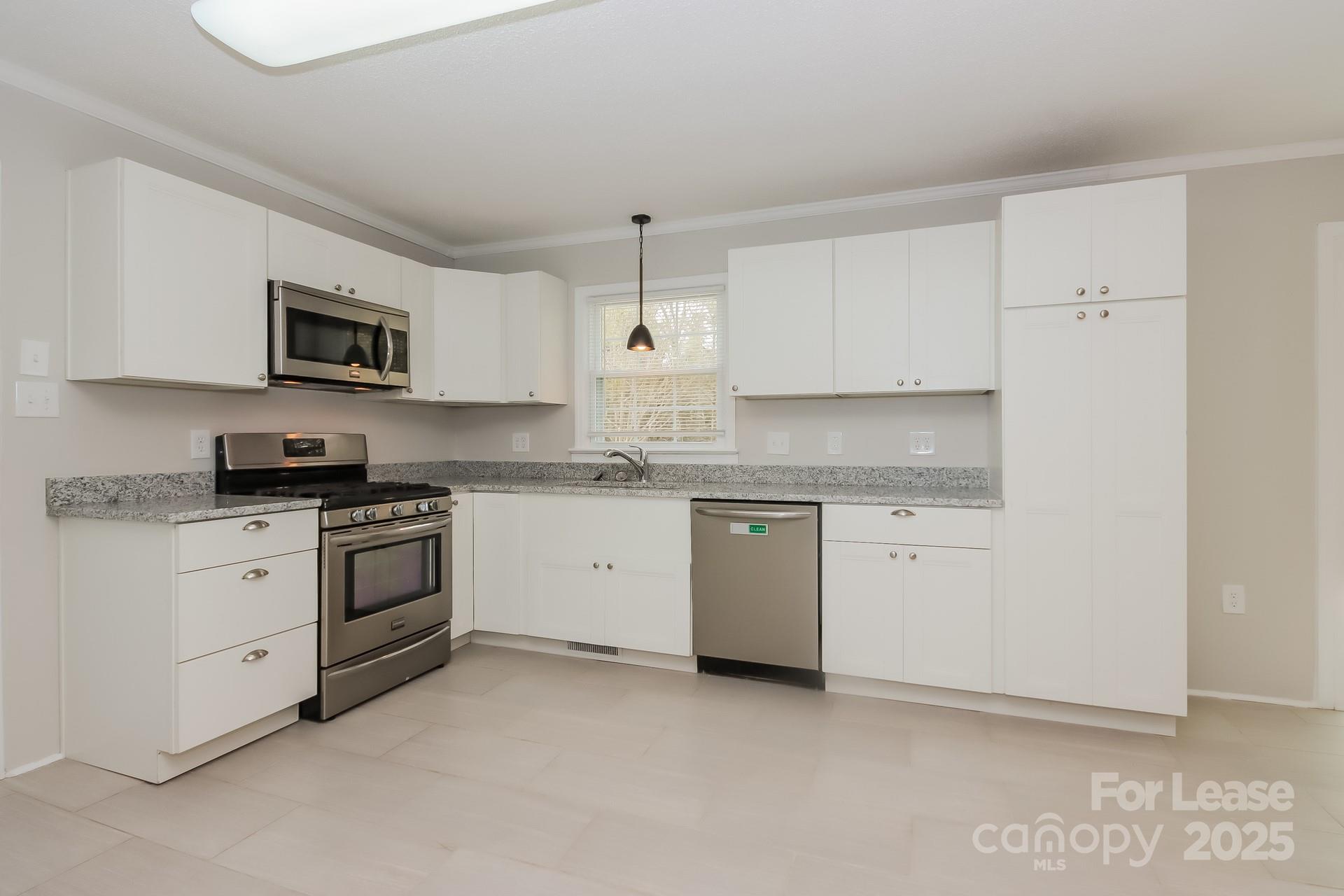 1135 Carolina Circle Statesville, NC 28677 - Photo 7 of 16 a kitchen with granite countertop a stove top oven sink and cabinets