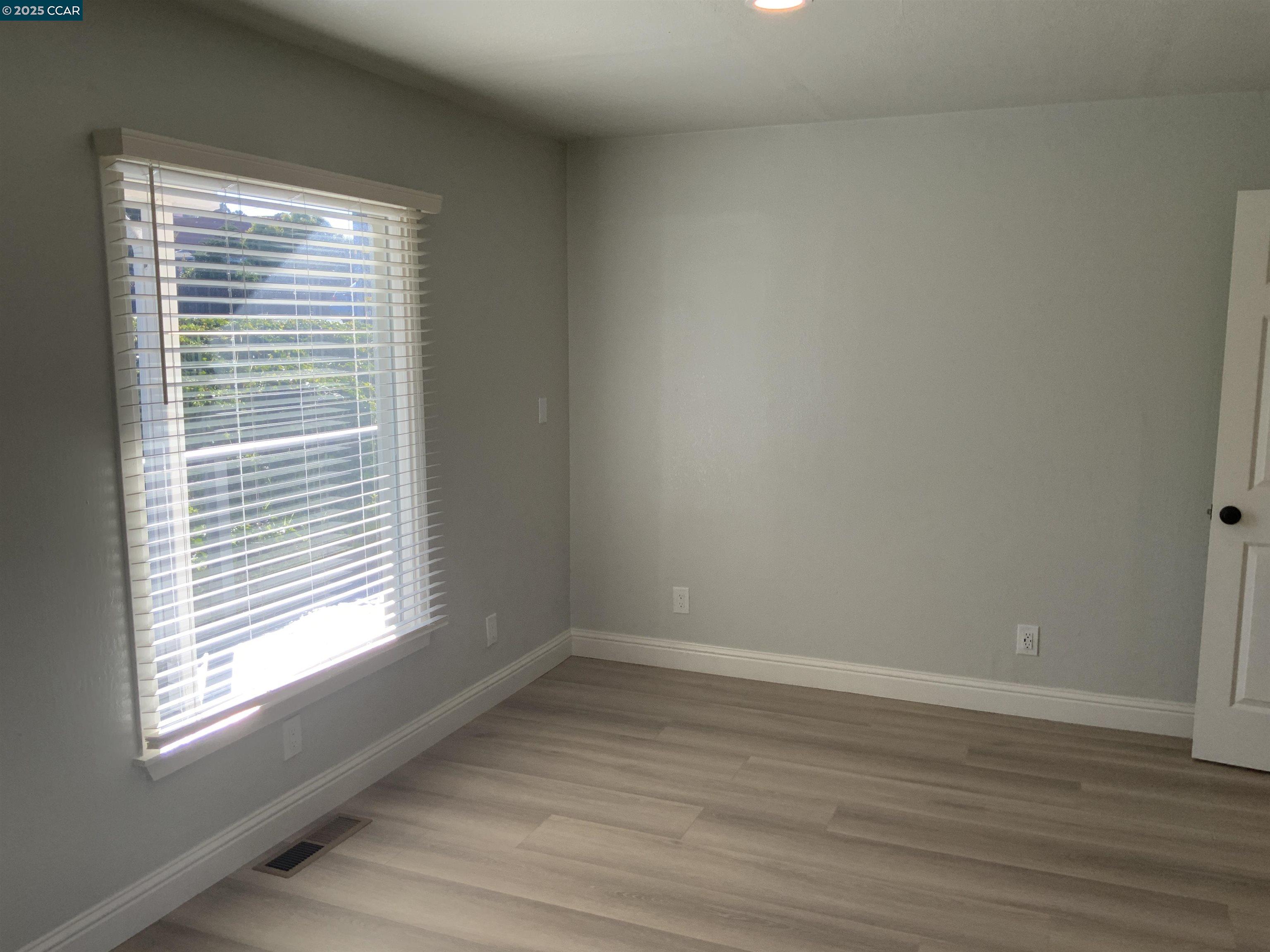 2680 Appian Way Pinole, CA 94564 - Photo 19 of 31 a view of an empty room with wooden floor and a window