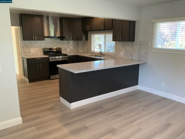 a kitchen with stainless steel appliances wooden cabinets a stove a sink and a refrigerator