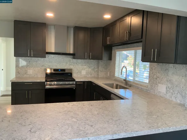 a kitchen with granite countertop stainless steel appliances and wooden cabinets
