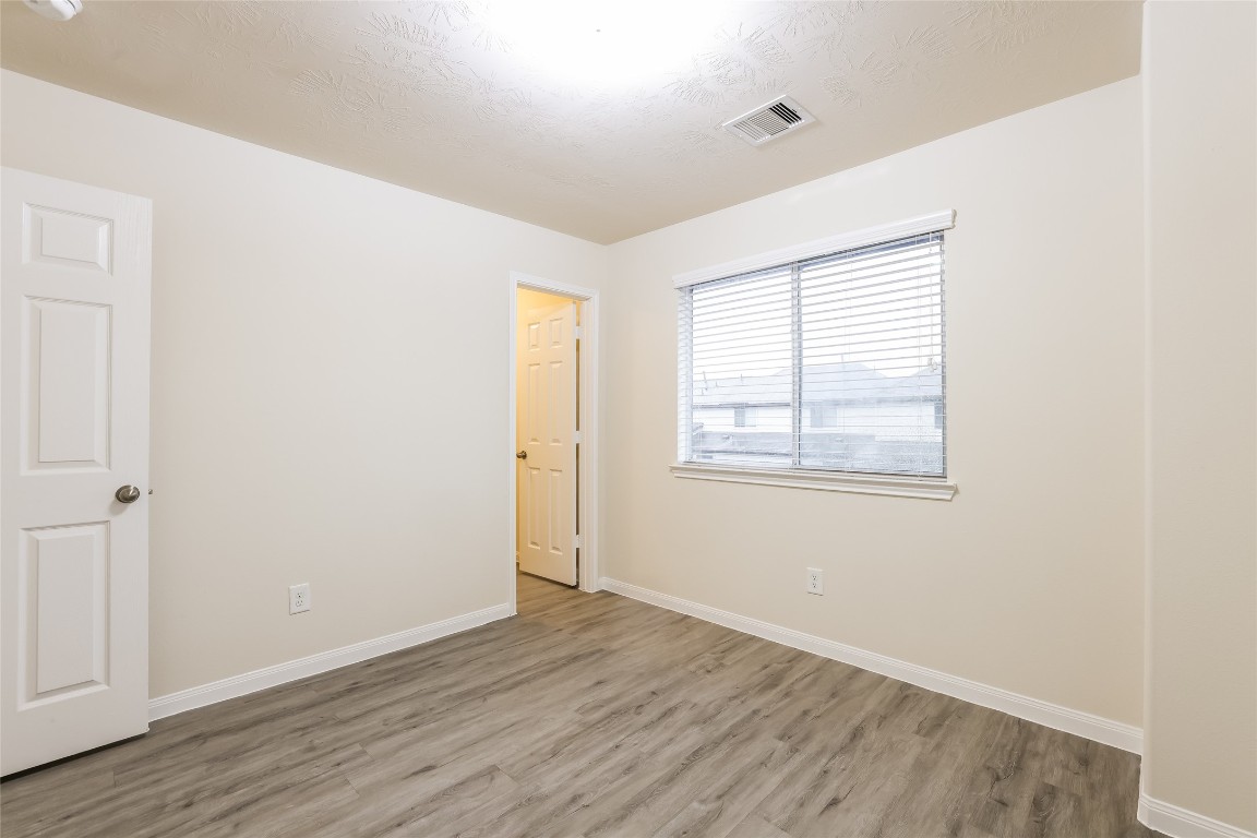 12330 Roy Mix Bohn Lane Houston, TX 77044 - Photo 13 of 17 an empty room with wooden floor and windows