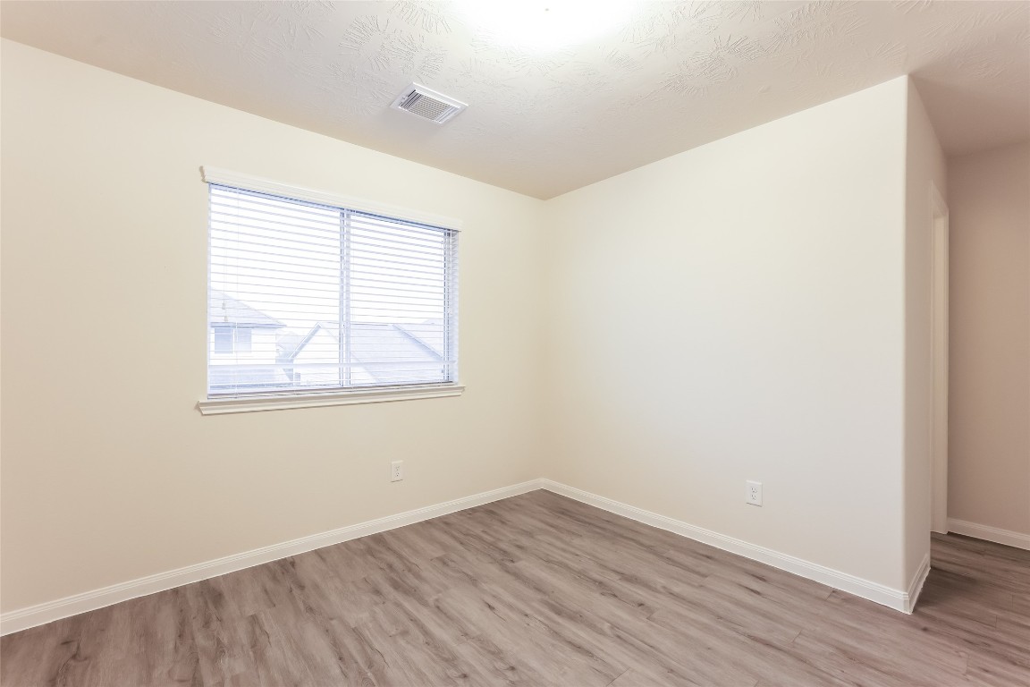 12330 Roy Mix Bohn Lane Houston, TX 77044 - Photo 14 of 17 an empty room with wooden floor and windows