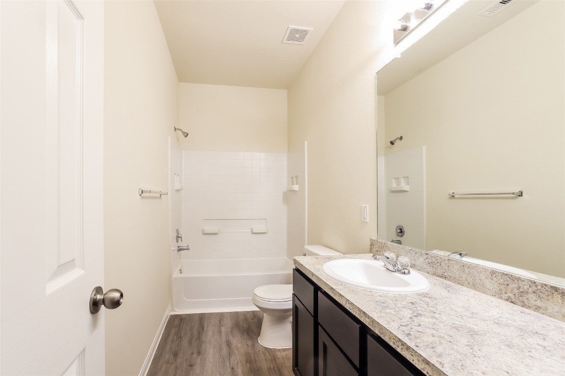 12330 Roy Mix Bohn Lane Houston, TX 77044 - Photo 11 of 17 a bathroom with a granite countertop sink a toilet and shower