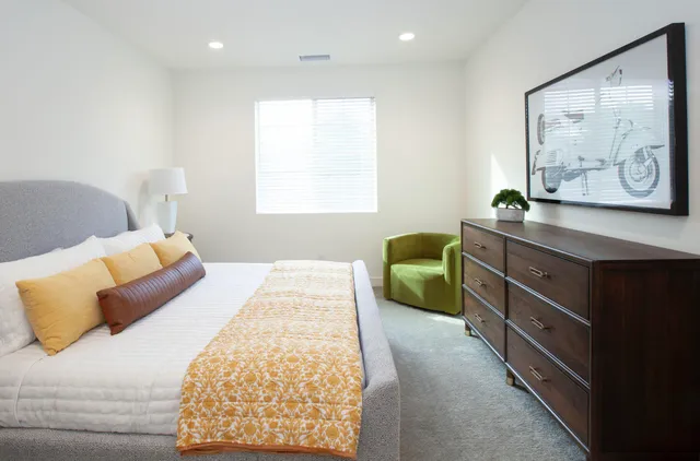 a bedroom with a bed and a painting on the wall