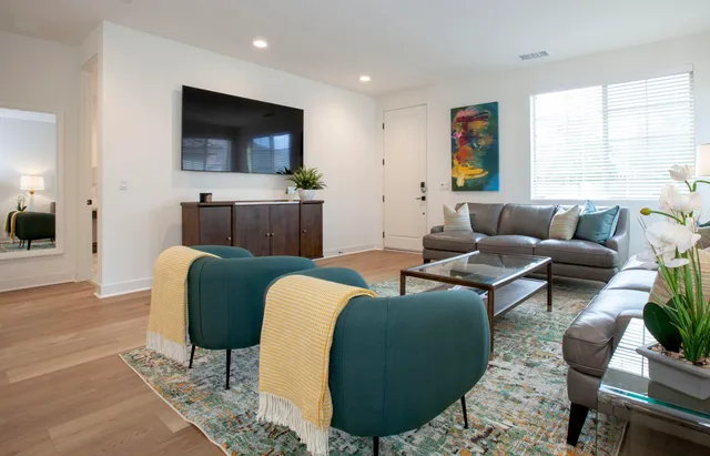 a living room with furniture a flat screen tv and a large window