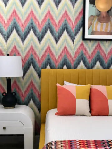 a bedroom with a bed and a painting on the wall