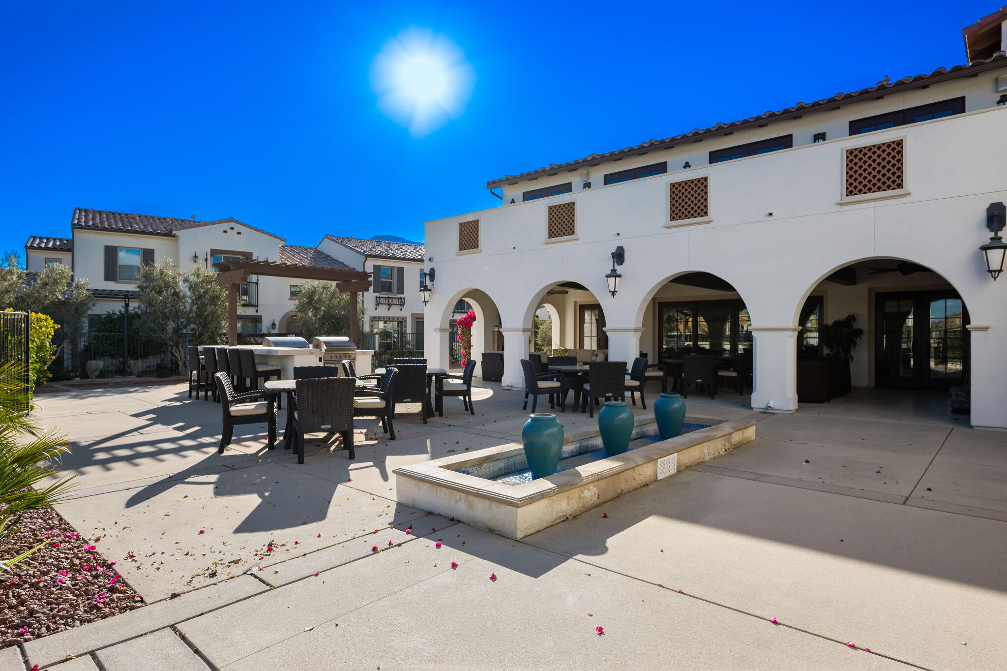 80215 Whisper Rock Way La Quinta, CA 92253 - Photo 56 of 63 a view of a patio with dining table and chairs with plants and a barbeque
