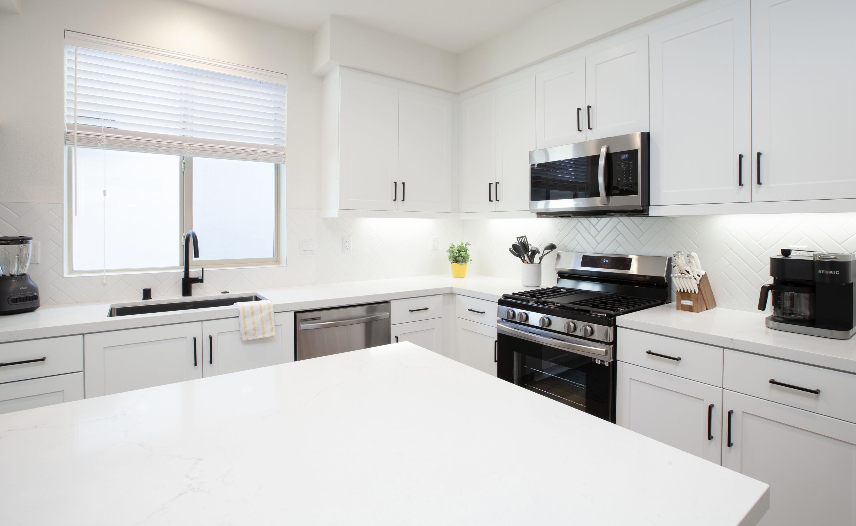 80215 Whisper Rock Way La Quinta, CA 92253 - Photo 8 of 63 a kitchen with white cabinets and appliances
