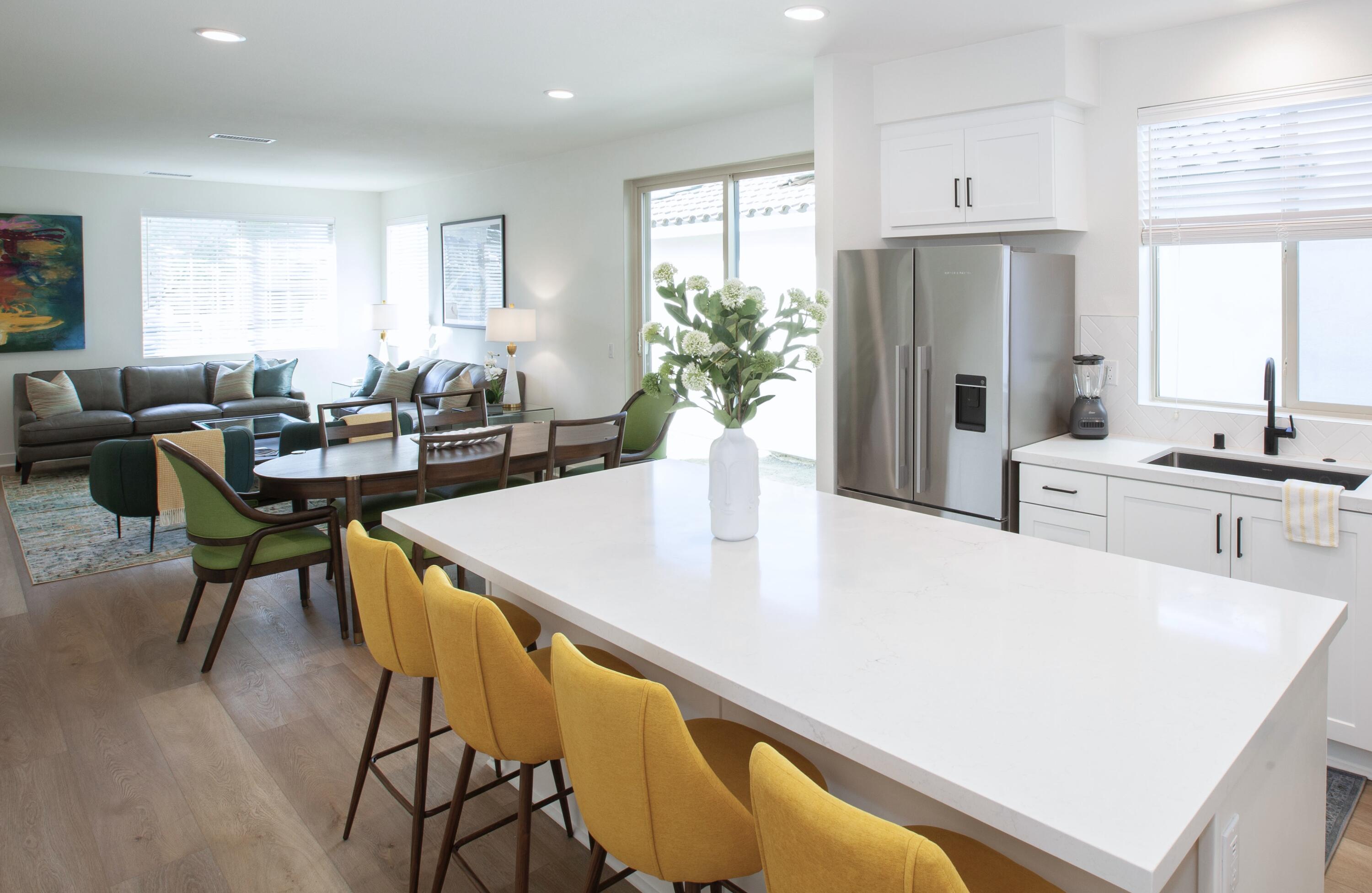 80215 Whisper Rock Way La Quinta, CA 92253 - Photo 10 of 63 a living room with stainless steel appliances kitchen island granite countertop a dining table chairs refrigerator and cabinets