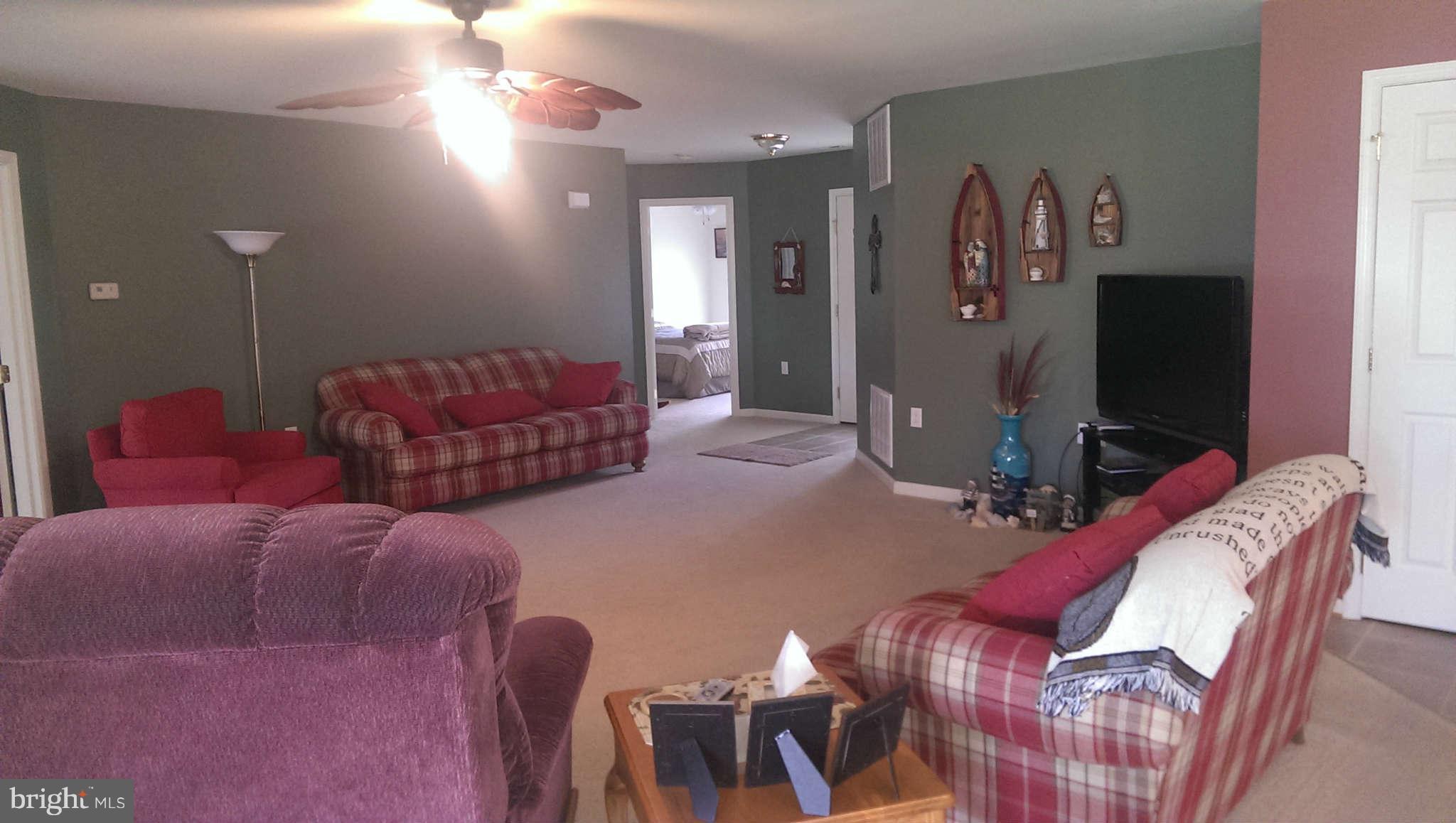 166 Peter Rabbit Drive Ranson, WV 25438 - Photo 10 of 14 a living room with furniture a flat screen tv and a wall painting
