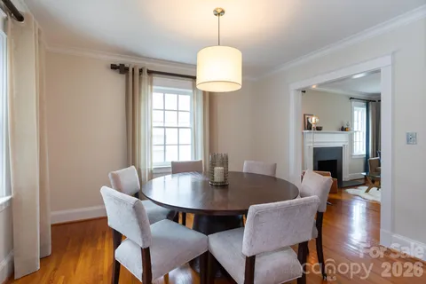a dining room with furniture wooden floor a rug and a chandelier