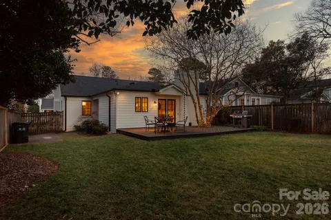 a view of a house with backyard and tree