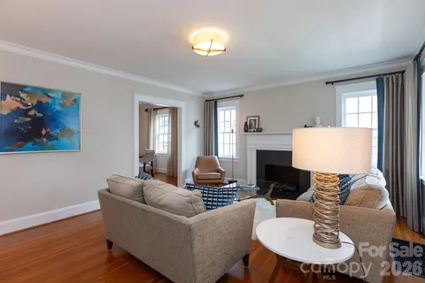 a living room with furniture a fireplace and a window