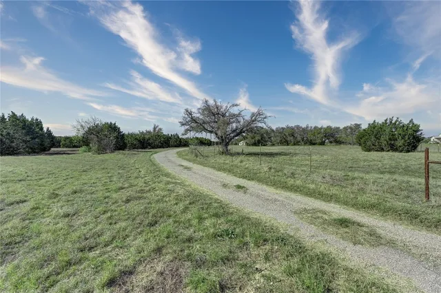 a view of a green field with wooden fence