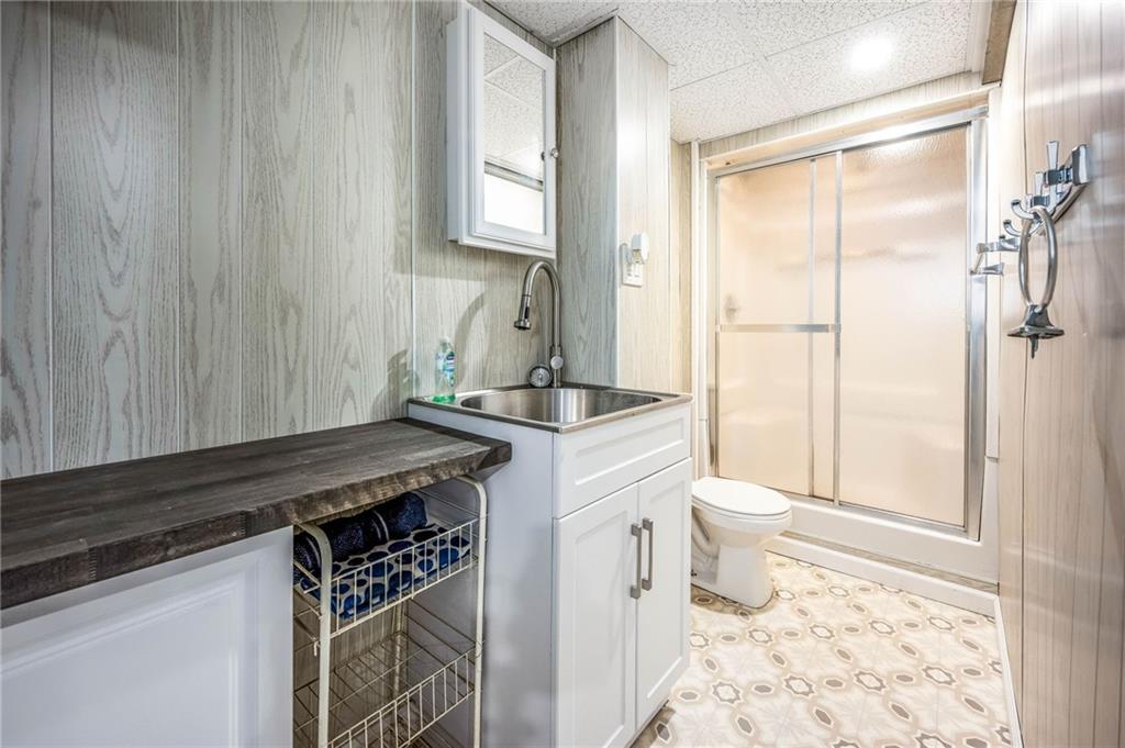 1380 Park Street Sharon, PA 16146 - Photo 22 of 39 a bathroom with a granite countertop sink a toilet a mirror and shower