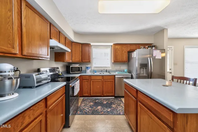 a kitchen with stainless steel appliances granite countertop a sink stove and refrigerator
