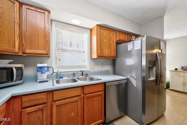 a kitchen with stainless steel appliances granite countertop a refrigerator sink and cabinets