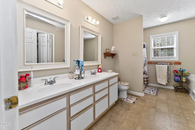 a bathroom with a tub a sink and a window
