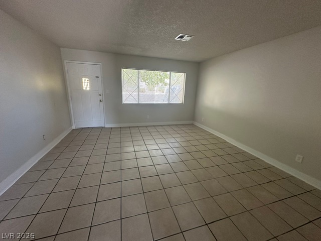 Tiled flooring and a wide window define this open living area.