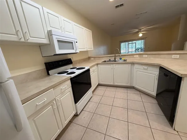 a kitchen with a stove sink and cabinets