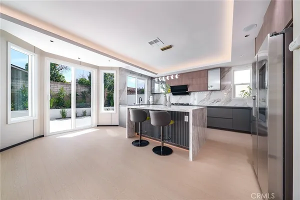 a living room with stainless steel appliances kitchen island furniture and a large window