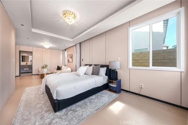 a spacious bedroom with a bed and a chandelier