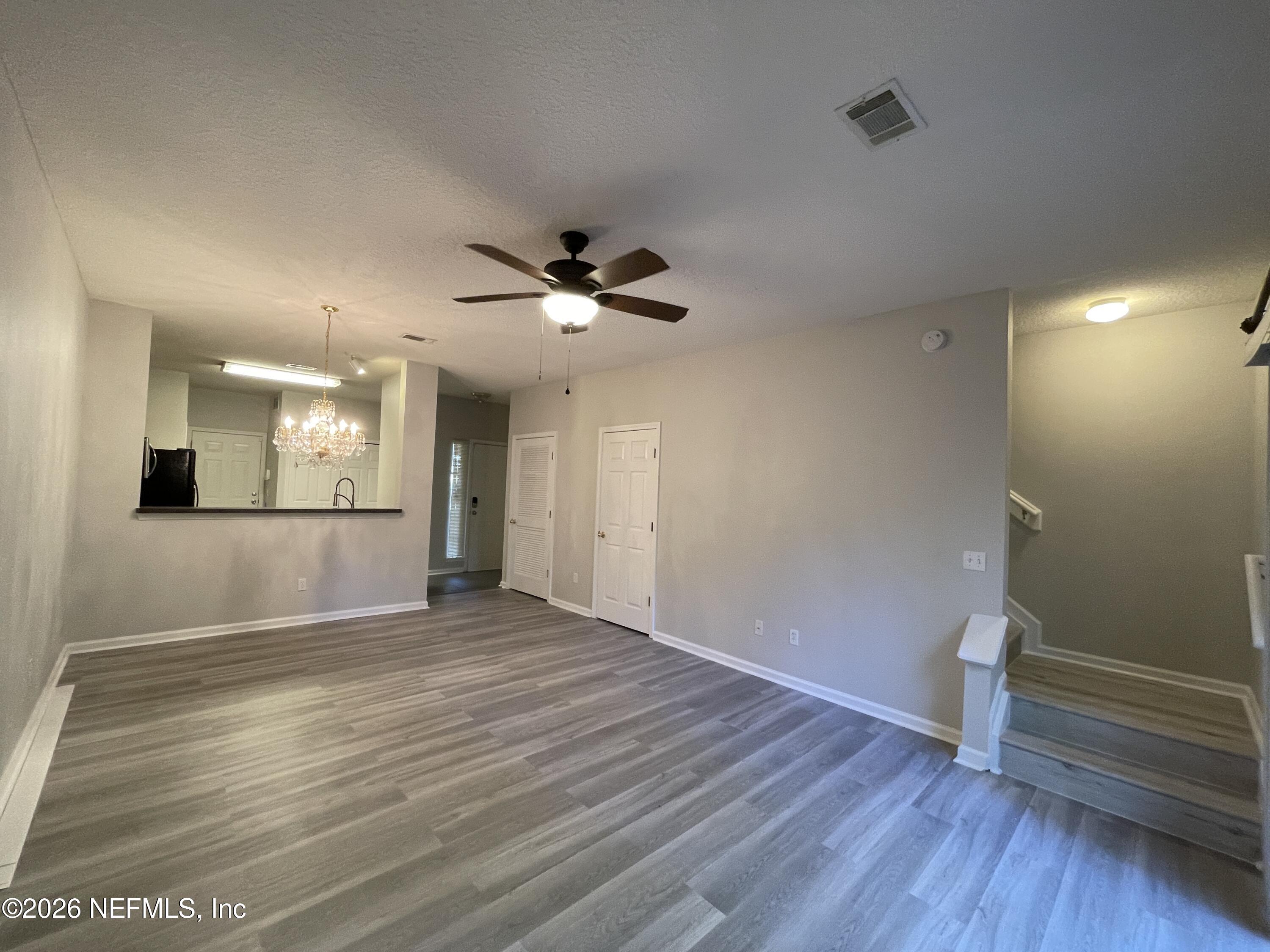 7931 Melvin Road Jacksonville, FL 32210 - Photo 4 of 18 an empty room with wooden floor and windows