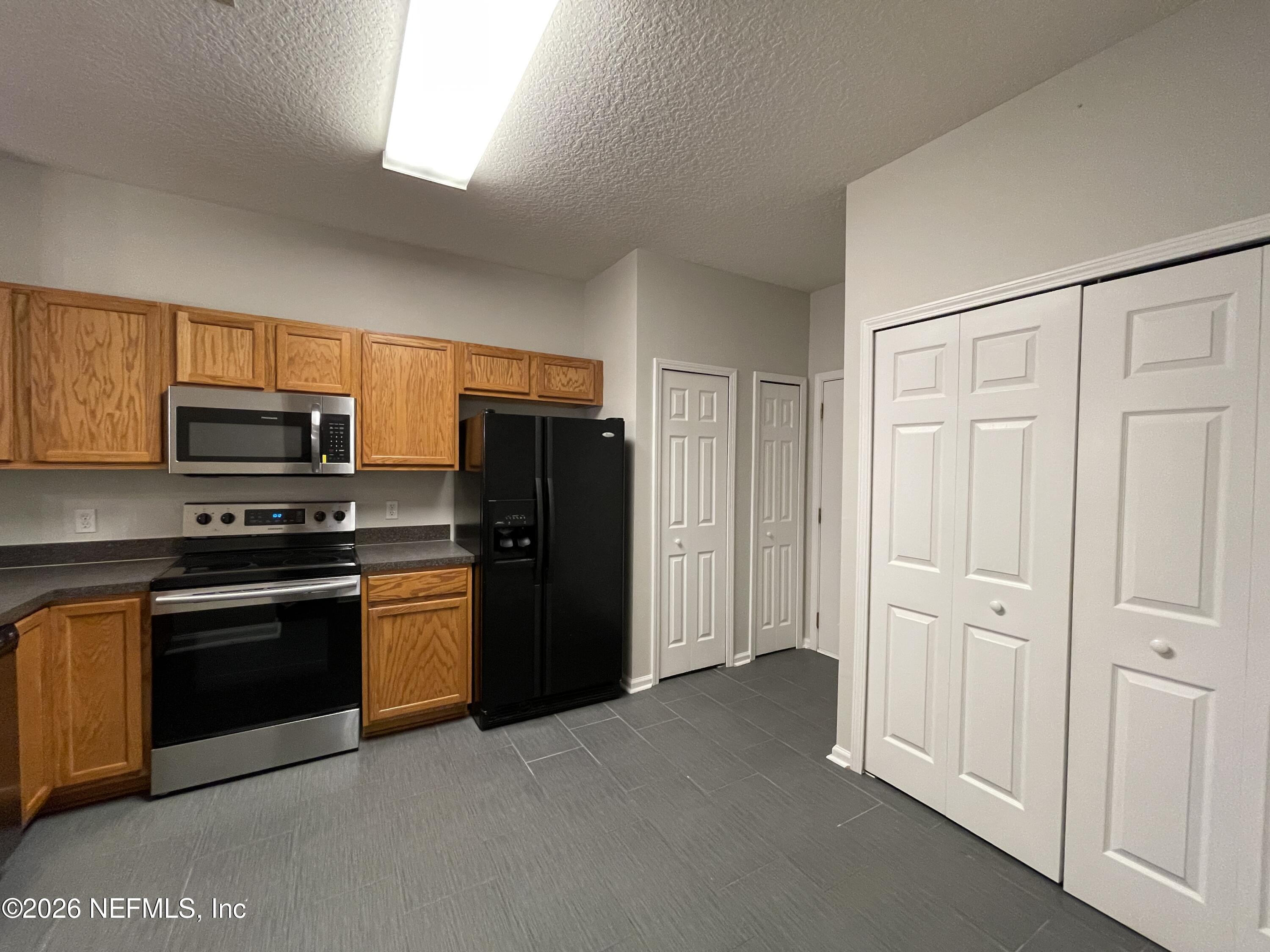 7931 Melvin Road Jacksonville, FL 32210 - Photo 6 of 18 a kitchen with stainless steel appliances granite countertop a refrigerator and a stove top oven